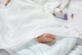 Close up patient baby feet sleep on bed at hospital with blur Saline intravenous drip on babyÃ¢â¬â¢s hand Royalty Free Stock Photo
